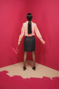 Rear view of a young woman holding a paint roller