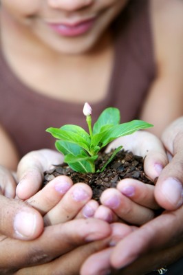 Girl with her mother holding a new flower