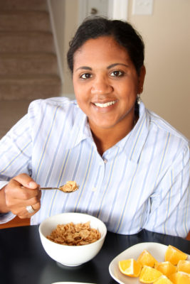 Woman eating her breakfast sitting at the table
